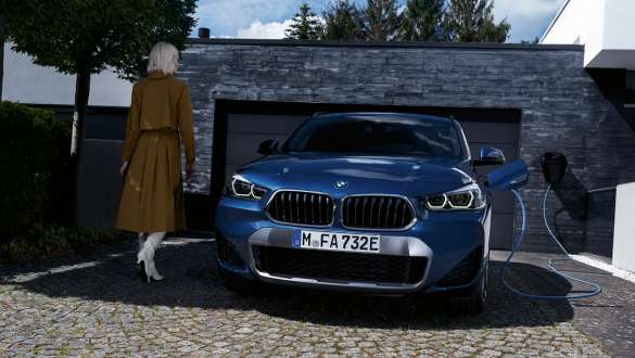 BMW X2 xDrive25e F39 ibrida Plug-in, vista anteriore davanti a garage BMW X2 xDrive25e F39 ibrida Plug-in Vista anteriore davanti a garage con modella