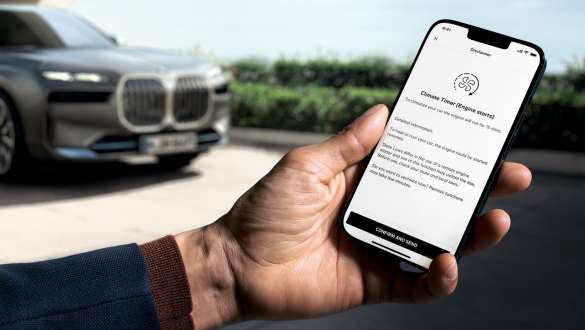 Remote Engine Start BMW Funzioni installabili in un secondo momento Funzioni installabili in un secondo momento BMW Remote Engine Start Smartphone in mano e BMW sullo sfondo