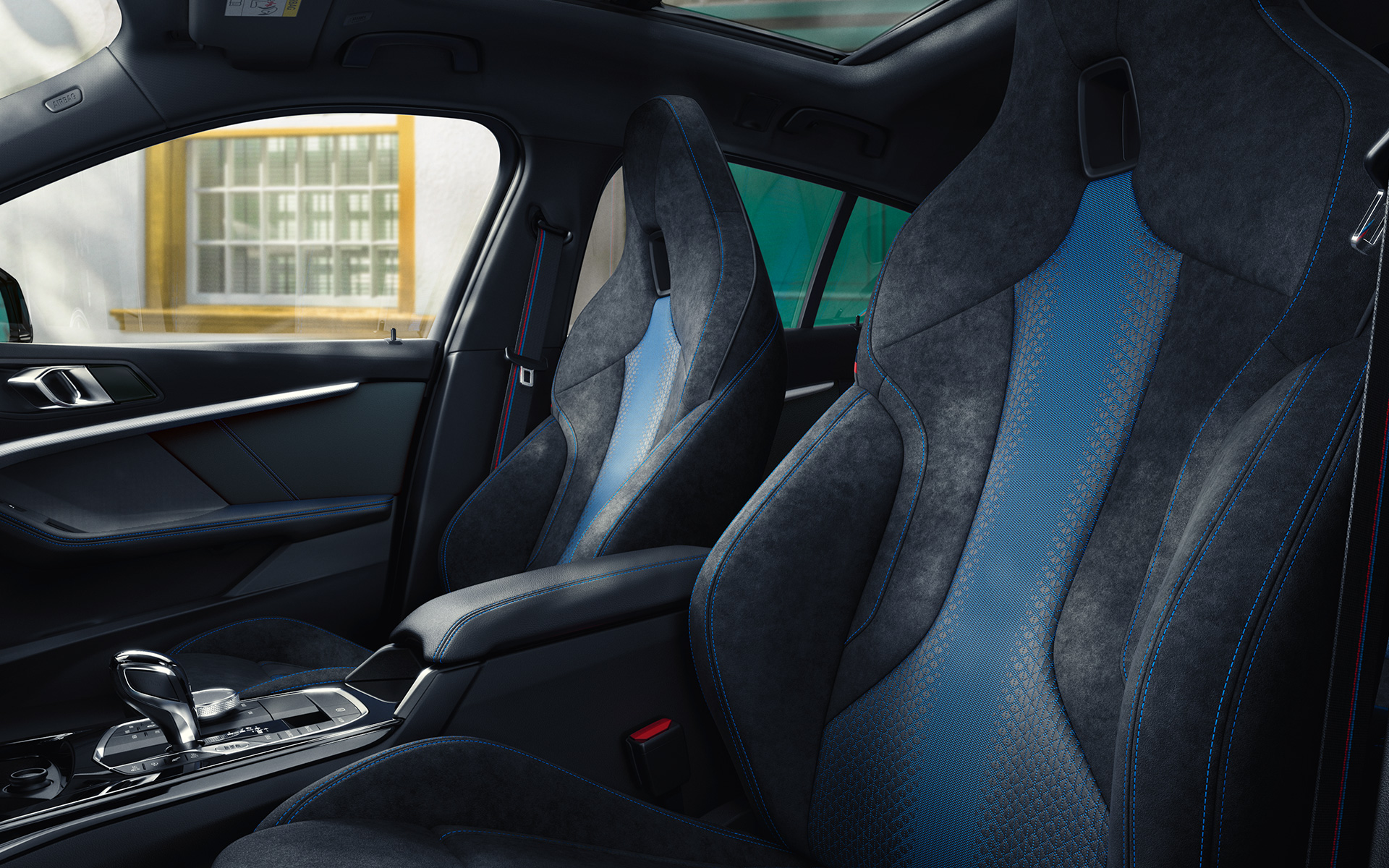 Sièges M sport de la BMW Série 1 F40 Sièges M sport au galbe ergonomique de la BMW Série 1 F40, avec surpiqûres contrastées bleues et appuie-têtes intégrés.