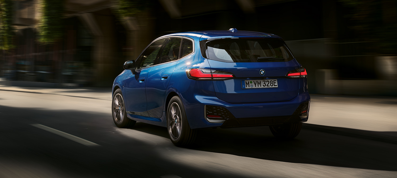 BMW 2er Active Tourer 230e Plug-in-Hybrid U06 2021 fahrend in der Stadt BMW 2er Active Tourer 230e Plug-in-Hybrid U06 2021 M Portimao Blau metallic Dreiviertel-Heckansicht fahrend in der Stadt