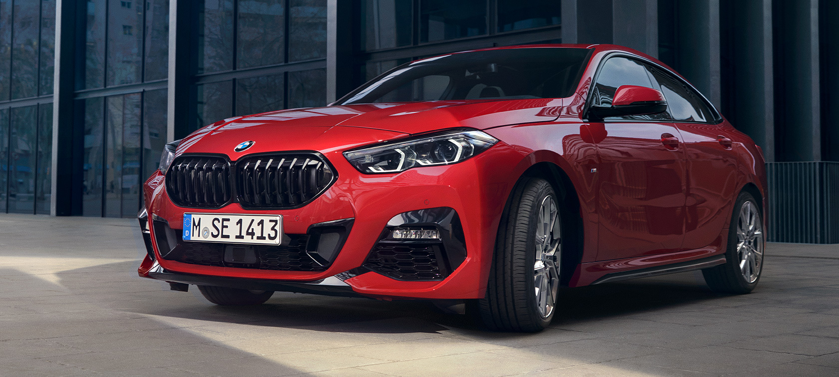 BMW 2er Gran Coupé F44 M135i Dreiviertel Frontansicht Edition ColorVision Melbourne Rot Metallic BMW 2er Gran Coupé F44 M135i Dreiviertel Frontansicht Edition ColorVision Melbourne Rot Metallic vor Gebäude