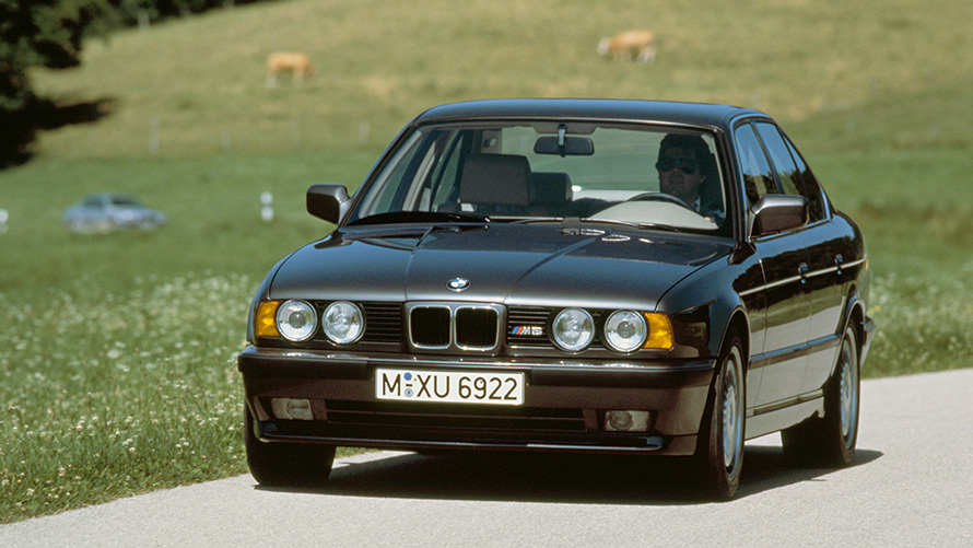 BMW M Berlina (E34) Vista anteriore a tre quarti in movimento BMW M Berlina (E34) Vista anteriore a tre quarti in movimento