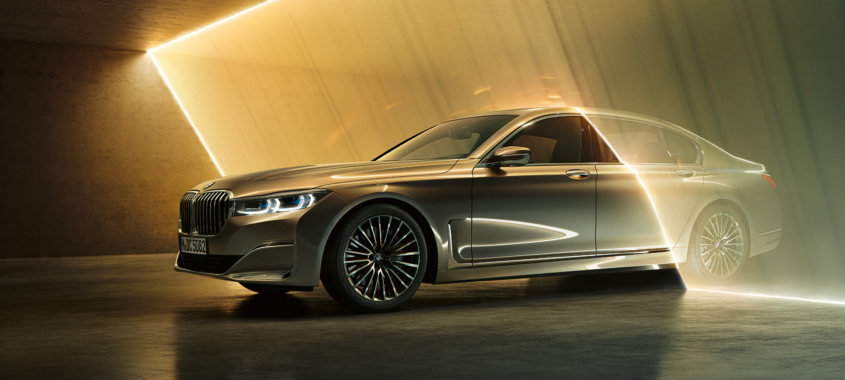 BMW 7er Limousine: Grauer BMW in Dreiviertel-Frontansicht umgeben von Lichtstrahlen