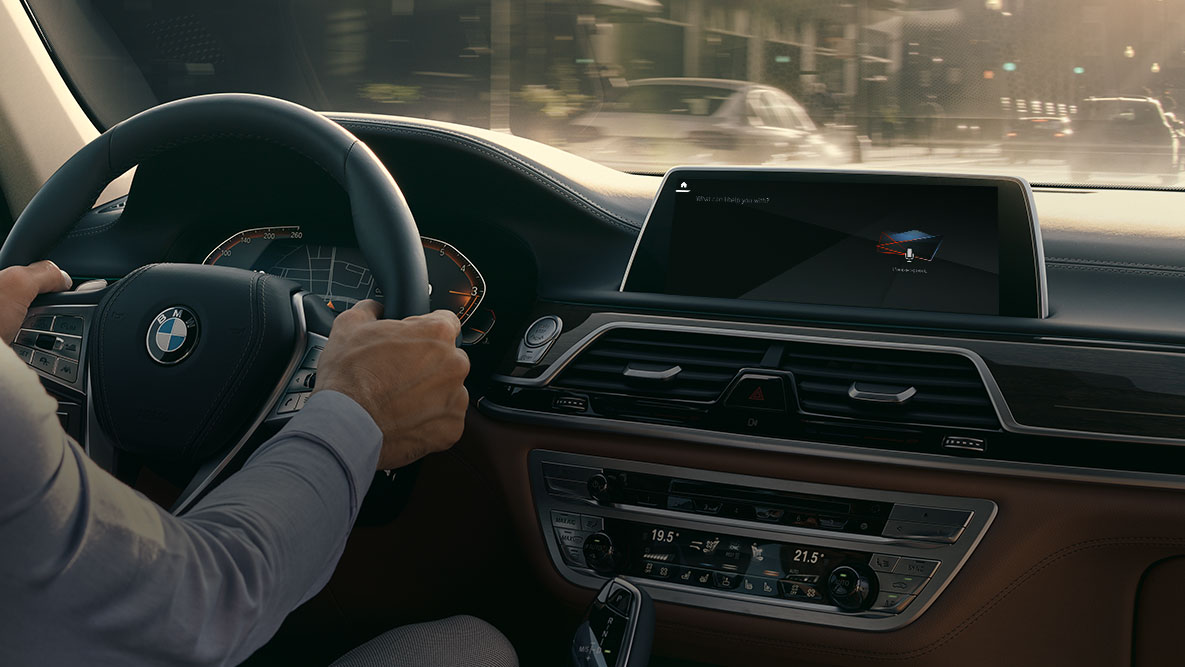 BMW Intelligent Personal Assistant BMW Intelligent Personal Assistant: Mann fährt in BMW, Nahaufnahme des Live Cockpit Professional