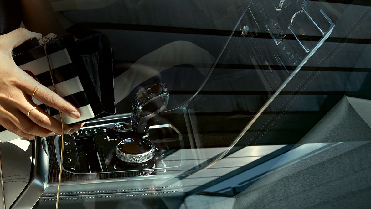 Interni della BMW M850i xDrive, applicazione in vetro CraftedClarity, donna con borsetta aperta. G14 Interni della BMW M850i xDrive, applicazione in vetro CraftedClarity, donna con borsetta aperta. G14