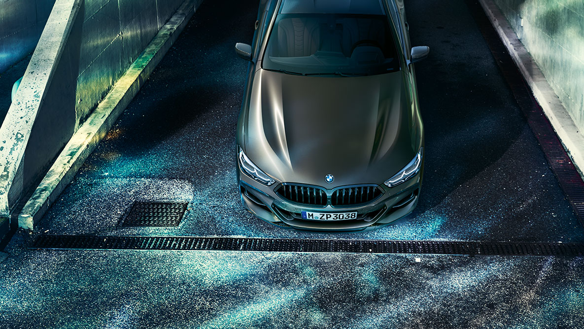 La BMW Série 8 Coupé photographiée à l'arrêt de face. G15 La BMW Série 8 Coupé avec équipement BMW Individual, photographiée à l'arrêt de face, dans un décor urbain de nuit. G15