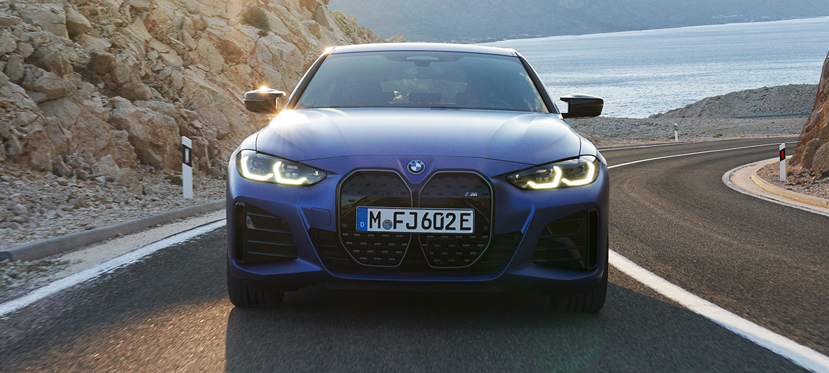 Vista anteriore BMW i4 M50 G26 2021 in movimento BMW i4 M50 G26 2021 M Portimao Blue metallizzato vista anteriore in movimento su strada