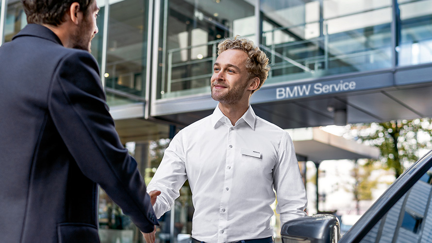 BMW Mitarbeiter begrüßt einen Kunden BMW Mitarbeiter begrüßt einen Kunden