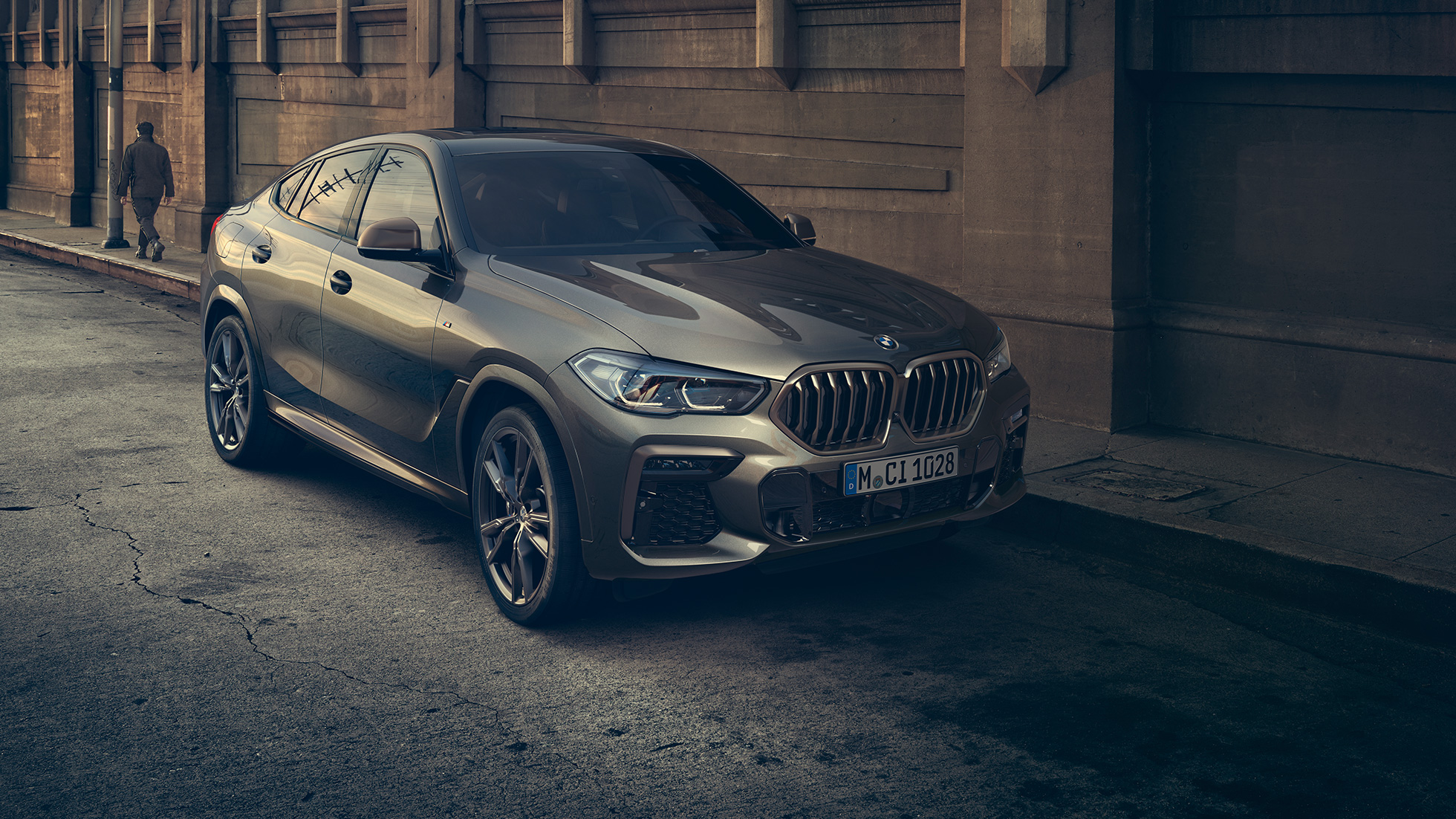 BMW X6 M50i standing. BMW X6 M50i in Dreiviertel-Front-Perspektive stehend vor urbaner Kulisse.
