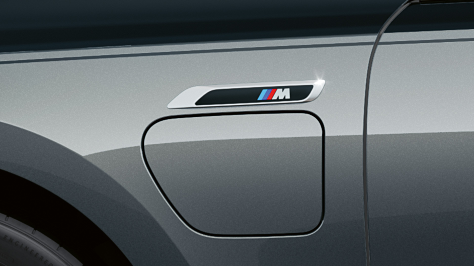 M-Badge BMW M760e xDrive Limousine G70 M-Badge BMW M760e xDrive Limousine G70 M Performance Paket BMW Individual Two-Tone Lackierung Saphirschwarz metallic BMW Individual Dravitgrau metallic Nahaufnahme Seitenansicht