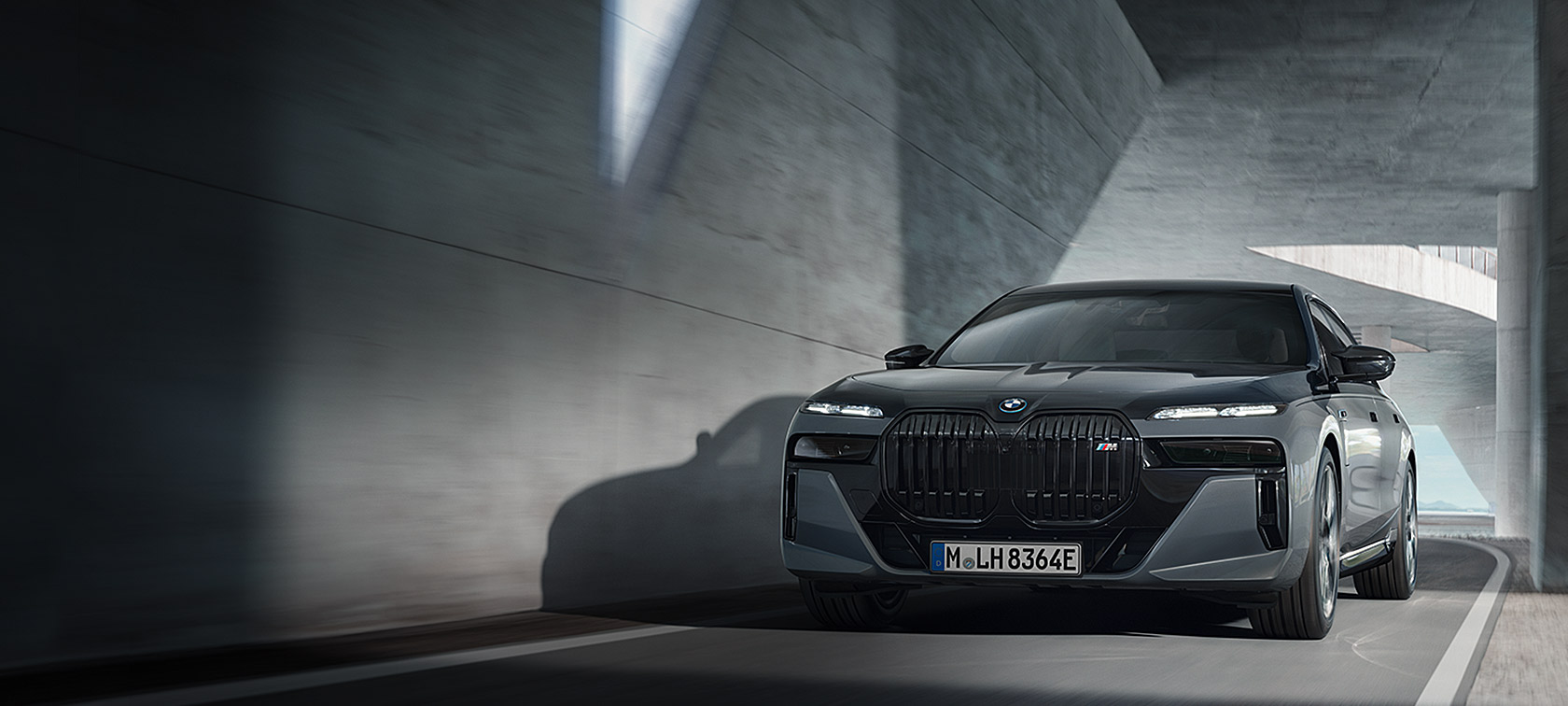 BMW M760e xDrive Limousine G70 M Performance Paket BMW Individual Two-Tone Lackierung Saphirschwarz metallic BMW Individual Dravitgrau metallic Dreiviertel Frontansicht fahrend auf der Strasse