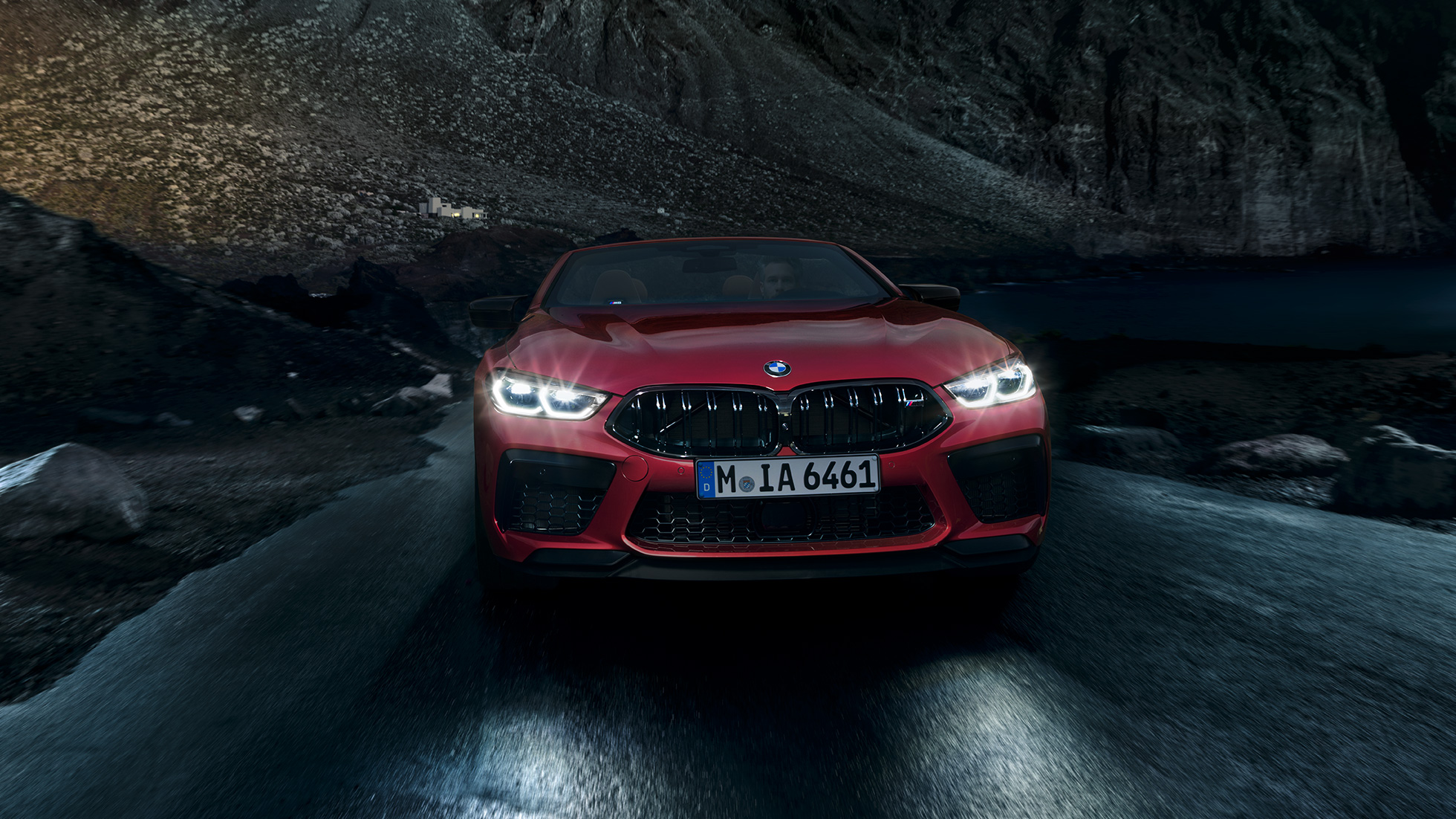 BMW M8 Competition Cabriolet, vista frontale. F91 BMW M8 Competition Cabriolet in Motegi Red metallizzato con fari accesi, vista frontale, in marcia di notte. F91