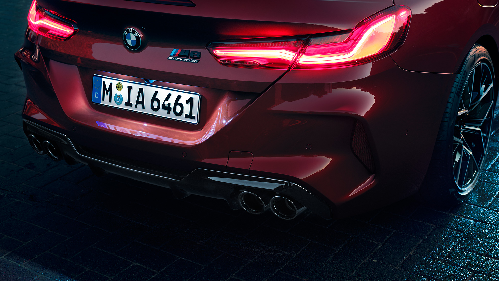 BMW M8 M Competition Cabriolet, primo piano del posteriore. F91 BMW M8 Competition Cabriolet in Motegi Red metallizzato, primo piano del posteriore con gruppi ottici a LED e M8 Competition Badge. F91