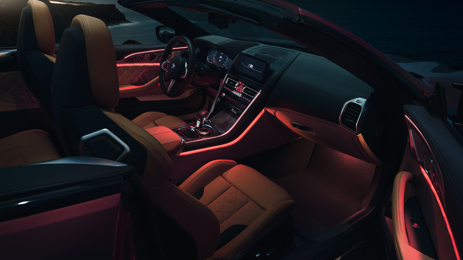 BMW M8 Competition Cabriolet, interni. F91 BMW M8 Competition Cabriolet con capote aperta, interni con luce ambiente rossa di notte. F91