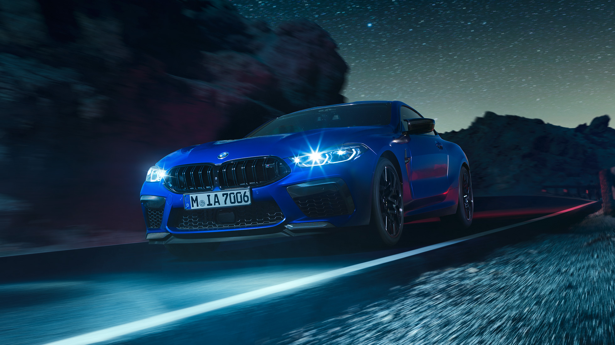 BMW M8 M Coupé in marcia, vista frontale di tre quarti. F92 BMW M8 Competition Coupé in Marina Bay Blue metallizzato con fari a LED accesi, vista frontale di tre quarti, in marcia di notte. F92