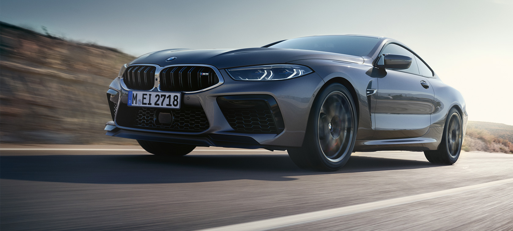 La BMW M8 Coupé F92 LCI restylage 2022 vue de trois quarts de profil en mouvement La BMW M8 Coupé F92 LCI Facelift 2022 Skyscraper Grau metallic vue de trois quarts de profil vue en contre plongée