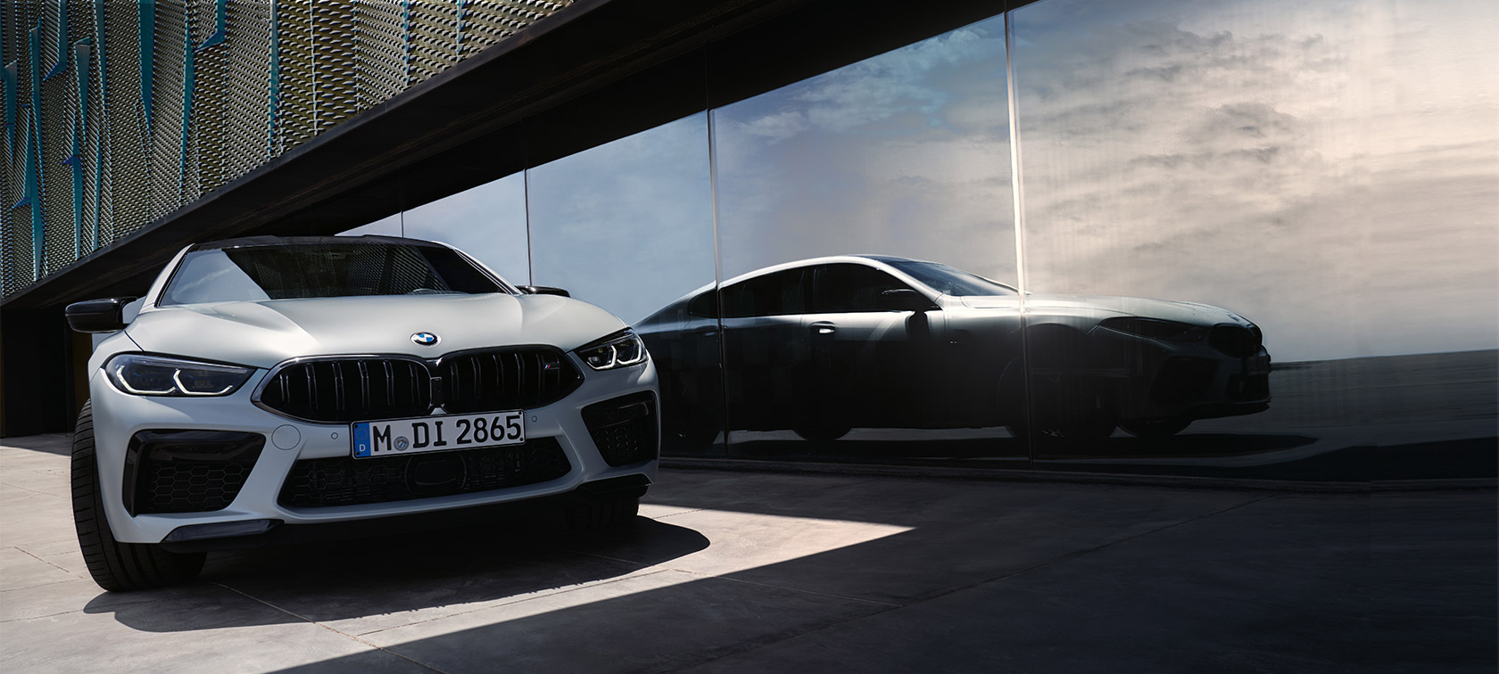 Frontansicht BMW M8 Competition Gran Coupé F93 LCI Facelift 2022 BMW M8 Competition Gran Coupé F93 LCI Facelift 2022 BMW Individual BMW Individual Frozen Brilliant White metallic Frontansicht mit Spiegelung der Silhouette an der Fensterfront