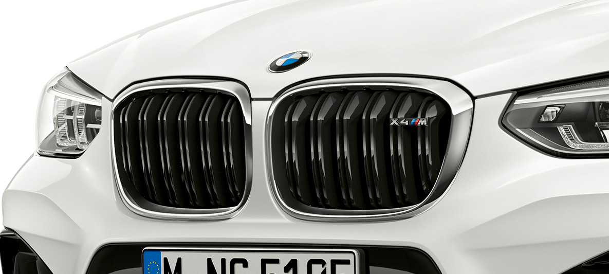 BMW X4 M, doppio rene M. F98 BMW X4 M in Alpine White, esterni, vista anteriore, doppio rene M con particolari cromati e denominazione del modello. F98