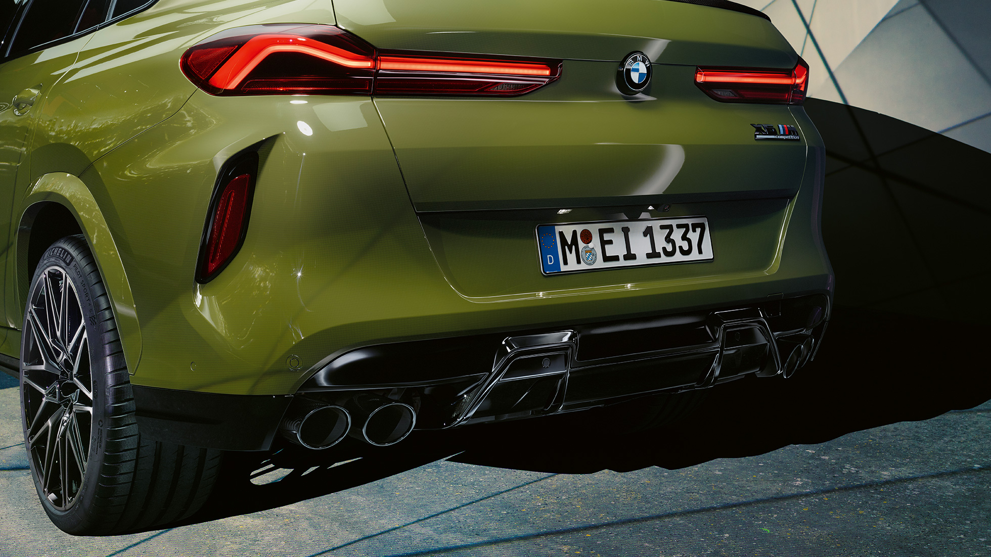 BMW X6 M Competition , vista posteriore a tre quarti BMW X6 M Competition con impianto di scarico sportivo M F96 Vernice esclusiva BMW Individual Urban Green, vista posteriore a tre quarti
