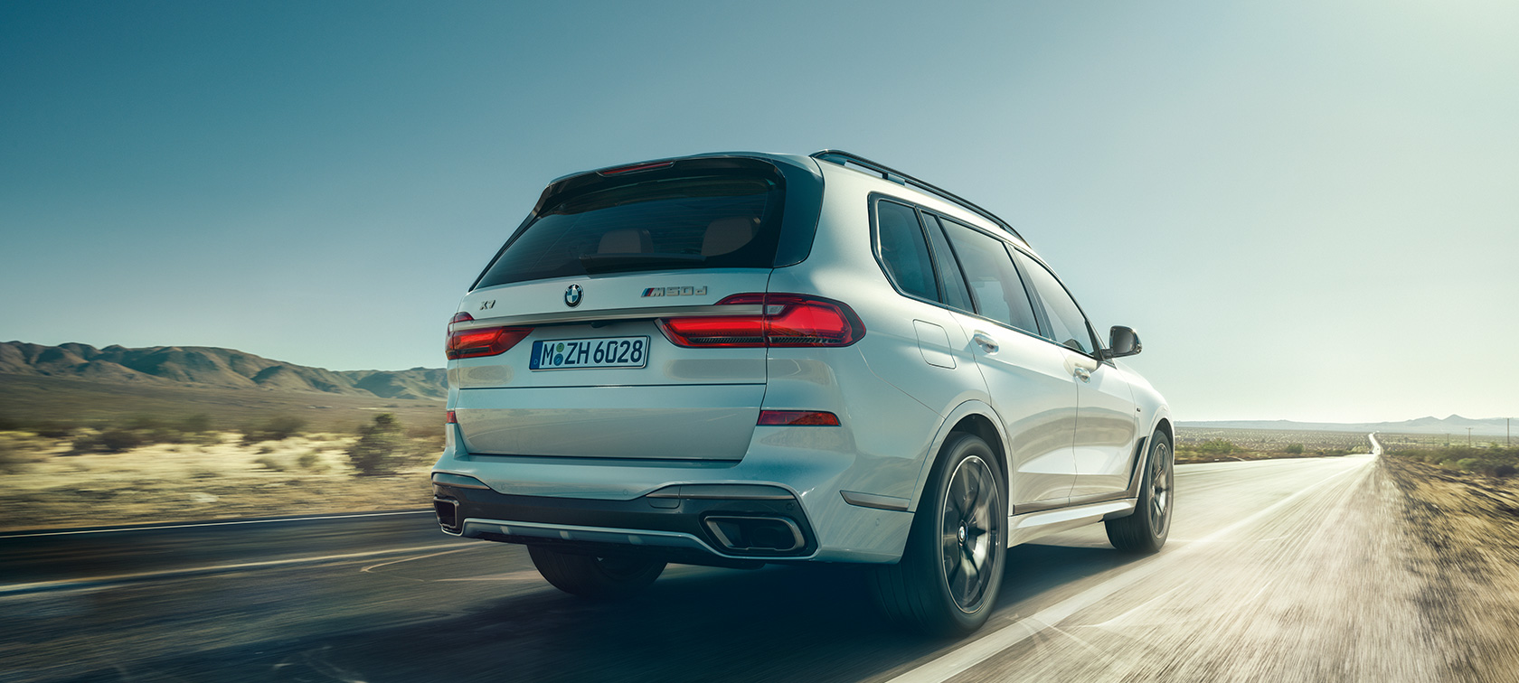 BMW X7 M50i, Heckansicht G07 BMW X7 M50i in Mineralweiß, fahrend auf einsamem Highway, Heckansicht, G07, 2019