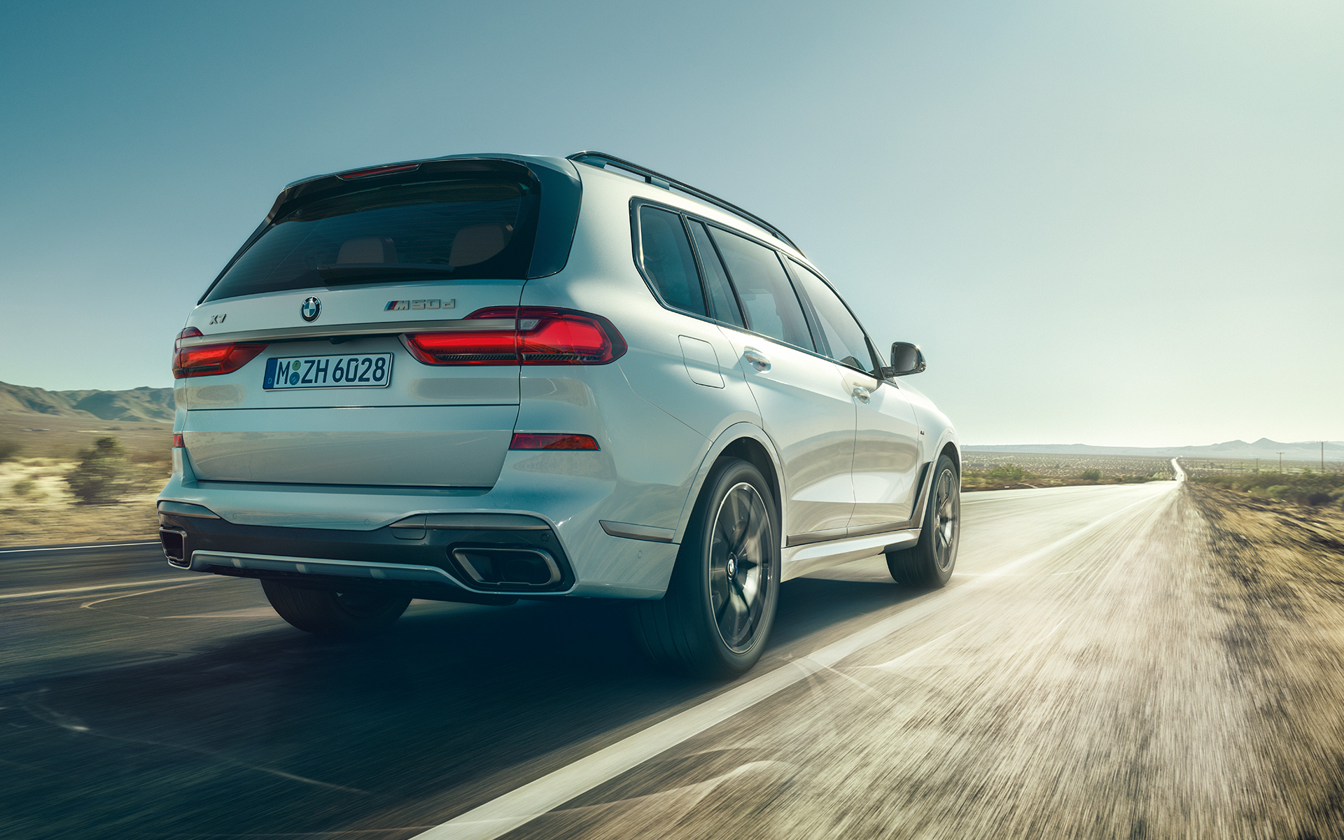 BMW X7 G07 2019 Mineralweiss Heckansicht fahrend BMW X7 G07 2019 Mineralweiss Heckansicht fahrend