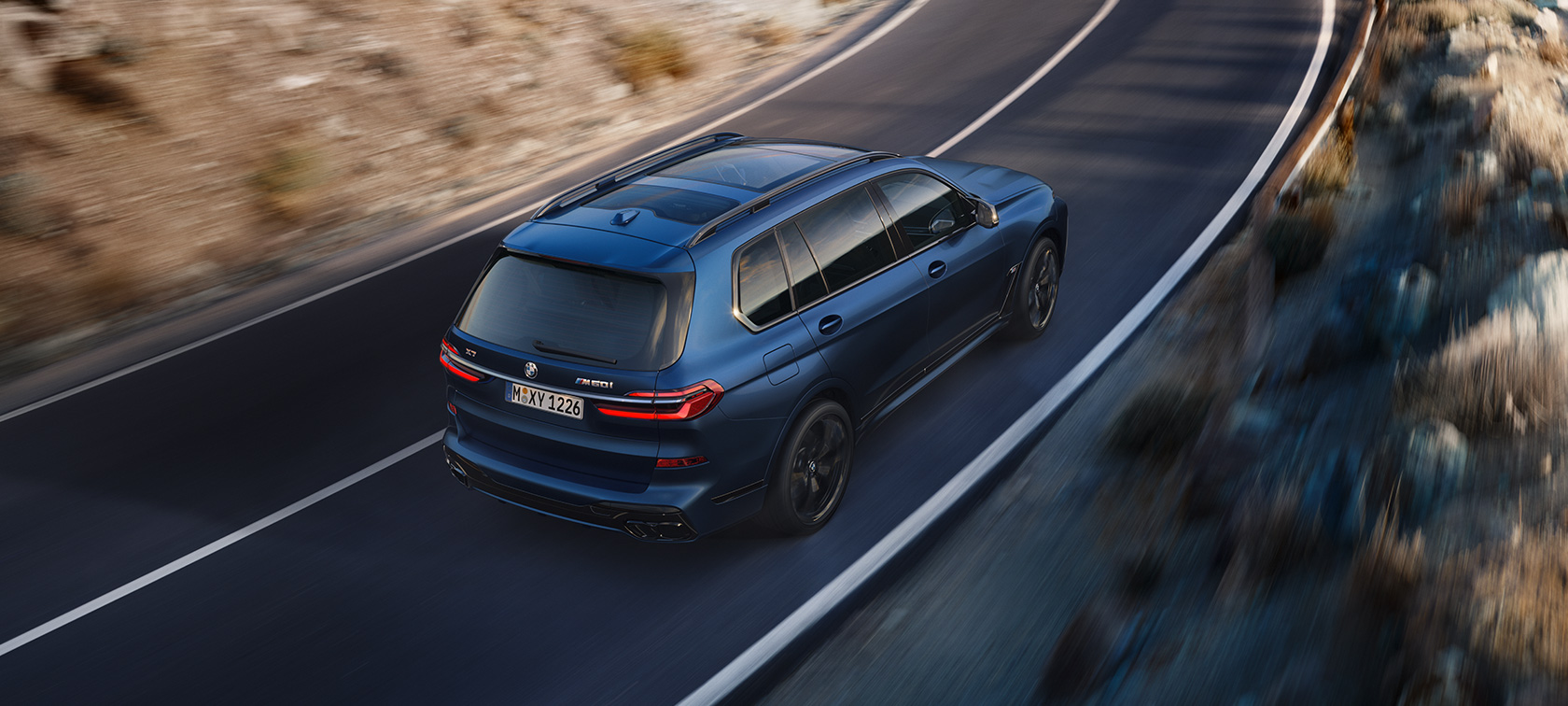 BMW X7 M60i xDrive G07 LCI Frozen Marina Bay Blue Dreiviertel-Heckansicht Vogelperspektive fahrend BMW X7 M60i xDrive G07 LCI Frozen Marina Bay Blue Dreiviertel-Heckansicht Vogelperspektive fahrend auf der Strasse