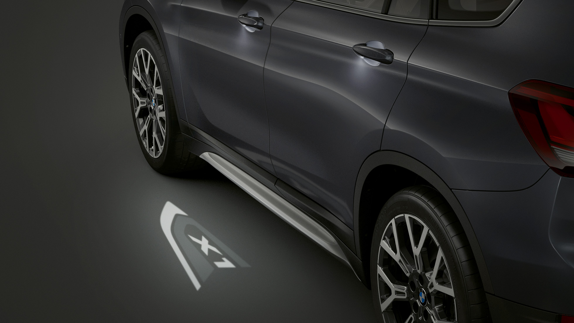 BMW X1, LED-Projektion “X1” F48. BMW X1, Seitenansicht mit Blick auf die LED-Projektion “X1” F48.