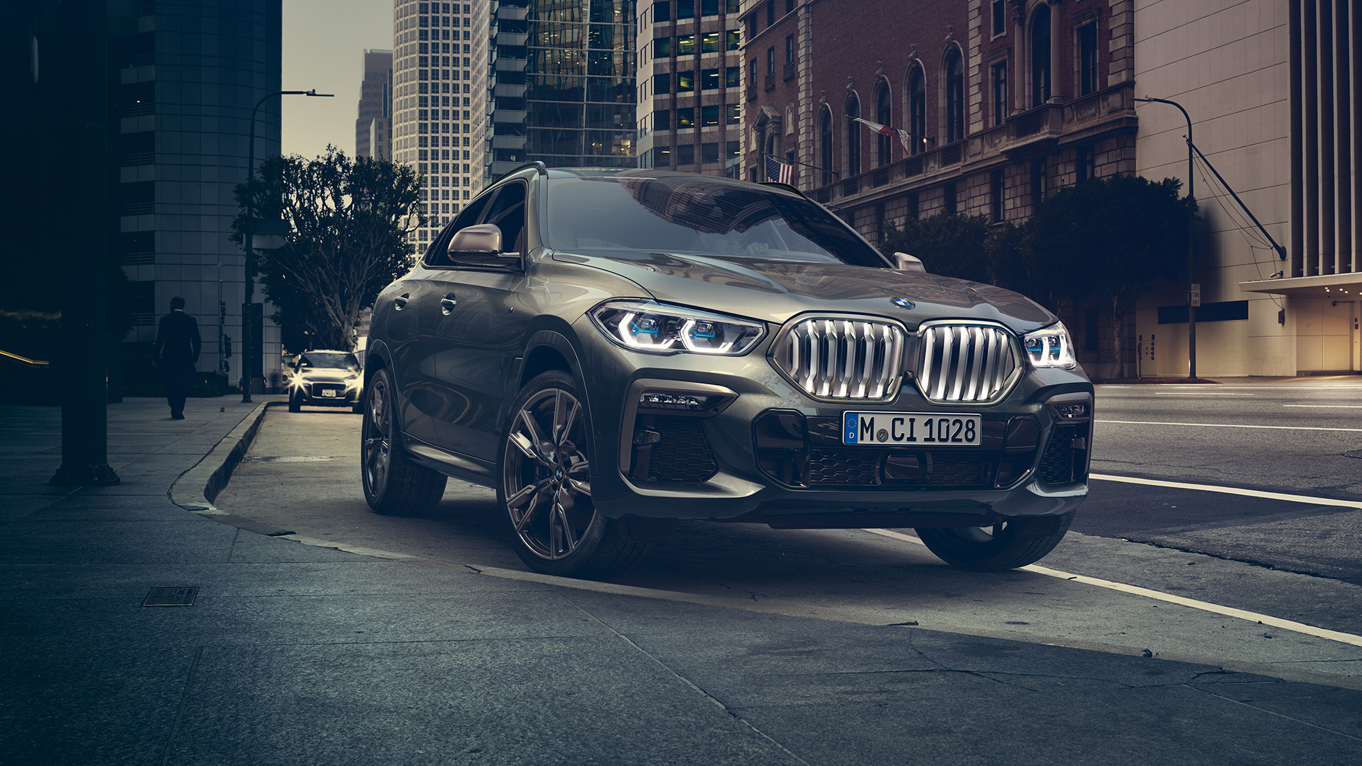 BMW X6, assetto adattivo M Professional G06 BMW X6, vista anteriore a tre quarti in ambiente urbano. G06