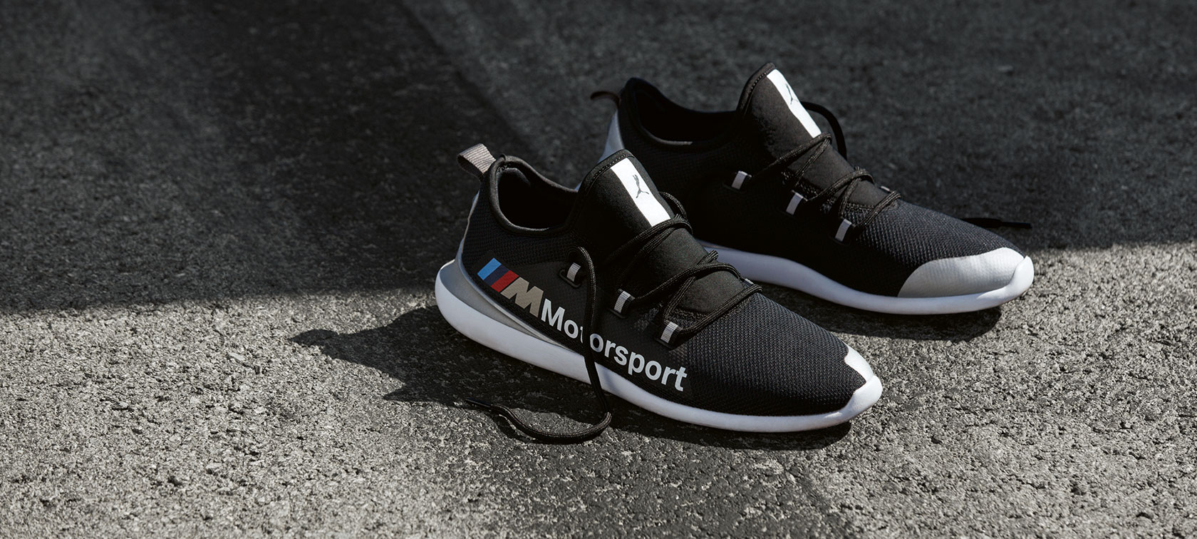 BMW M Motorsport Schuhe PUMA EVO CAT. BMW M Motorsport Schuhe PUMA EVO CAT aus der BMW M Motorsport Collection stehen auf Asphalt.