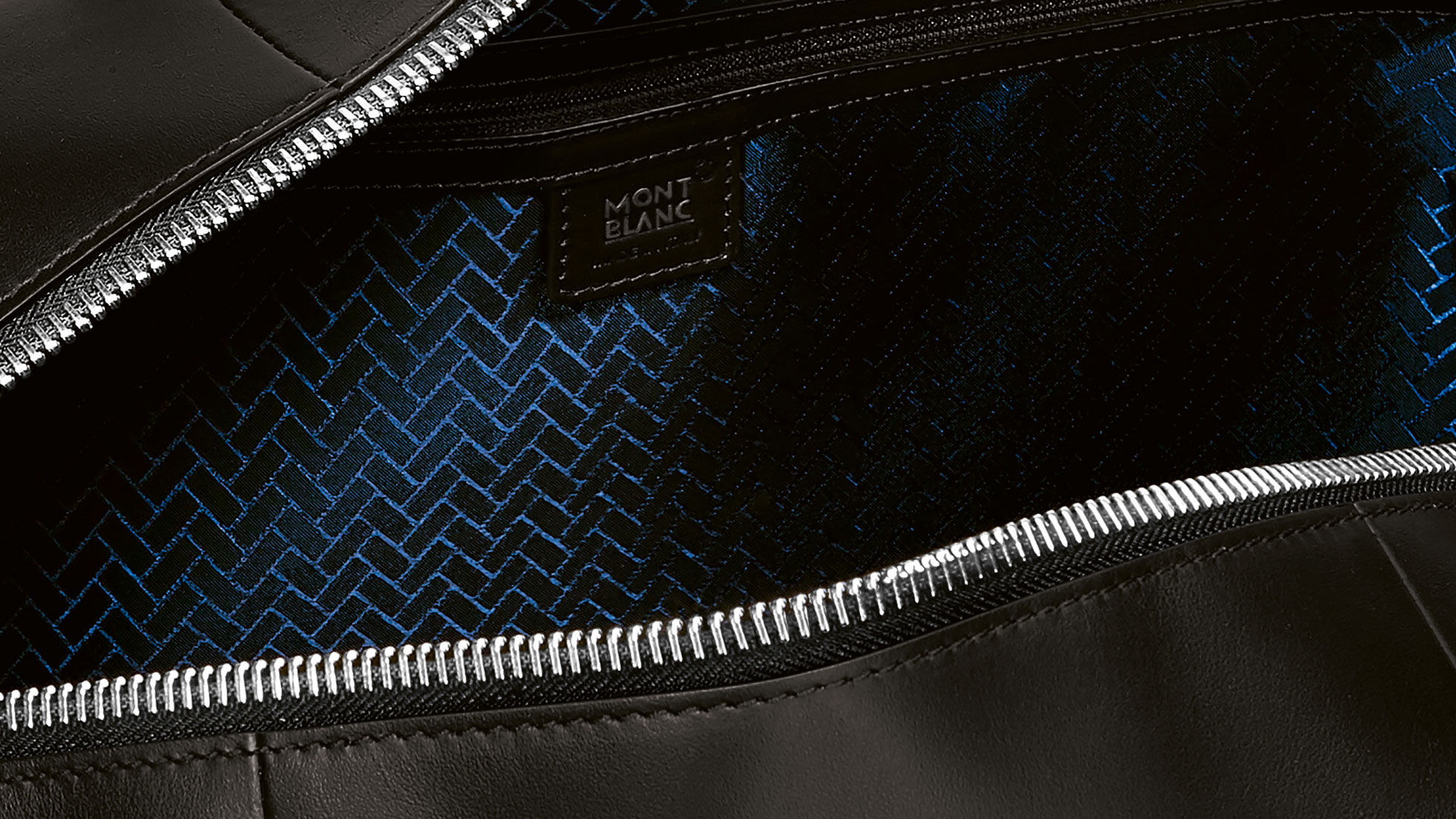 Montblanc for BMW Reisepasshülle. Im Bild ist eine Grossaufnahme des Musters der Montblanc for BMW Duffle Bag zu sehen.