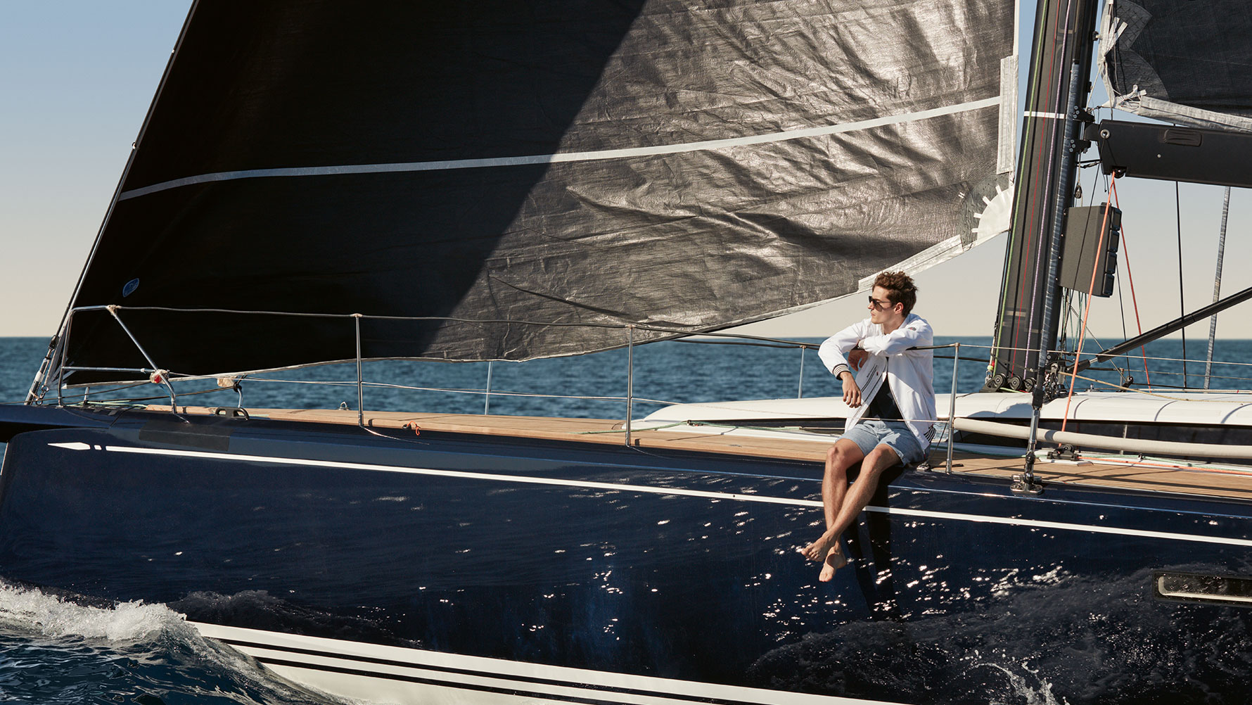 Un uomo seduto su uno yacht a vela indossa una Giacca BMW Yachtsport, da uomo, della BMW Yachtsport Collection. Un uomo seduto su uno yacht a vela indossa una Giacca BMW Yachtsport, da uomo, della BMW Yachtsport Collection.