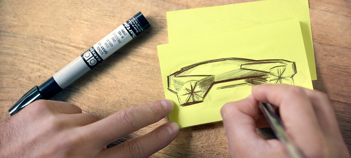 Schizzi di BMW Vision iNEXT Mani che disegnano schizzi di BMW Vision iNEXT su post-it