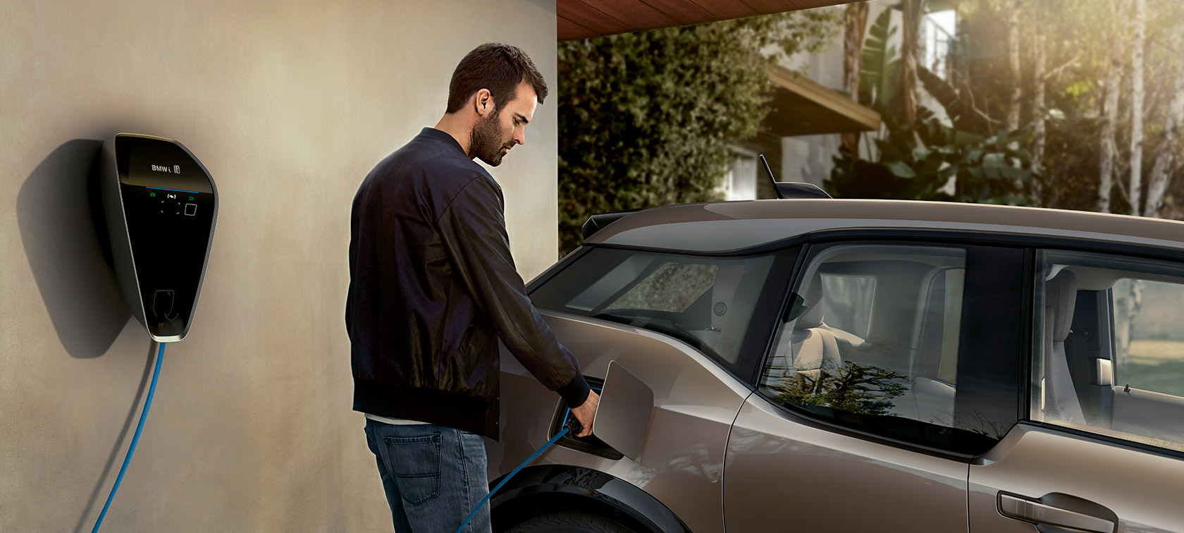 Mann lädt BMW i3. Mann lädt BMW i3 an der BMW i Wallbox auf.