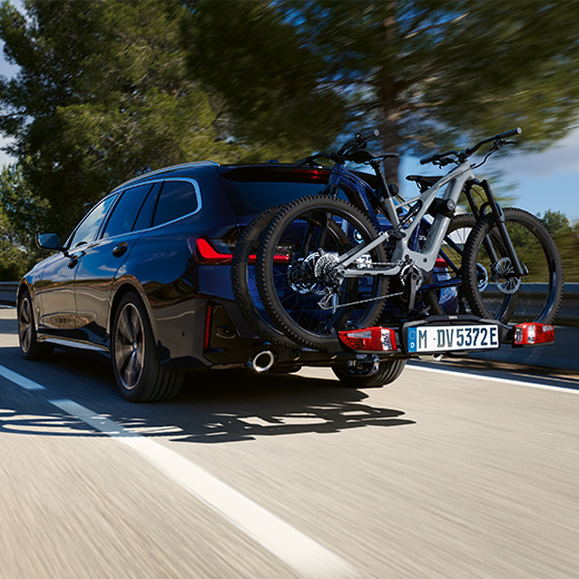 BMW Série 3 Touring G21 PHEV Vue arrière 3/4 en mouvement avec des vélos