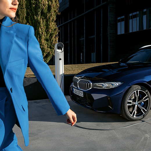 Situation de recharge avec femme BMW qui marche au premier plan