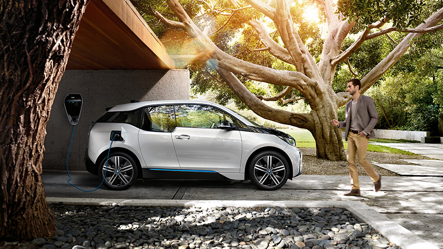 Wallbox BMW i3 Wallbox homme BMW i3 blanc vue latérale arbre entrée de maison