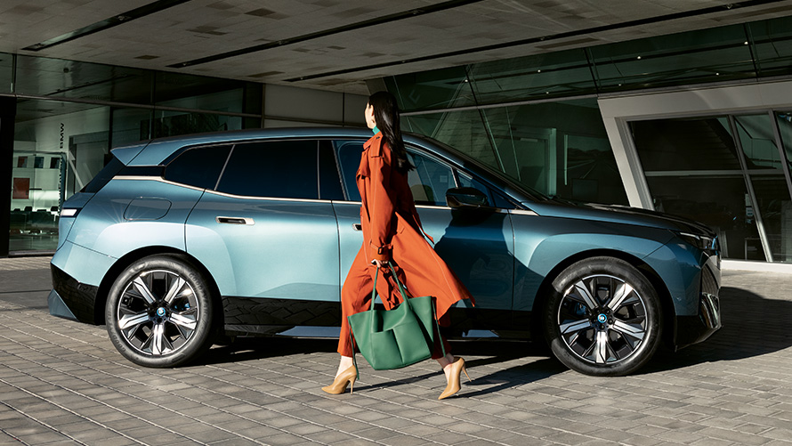 Utilisation de la BMW Digital Key Utilisation de la BMW Digital Key BMW iX i20, vue de profil avec femme à l'avant-plan