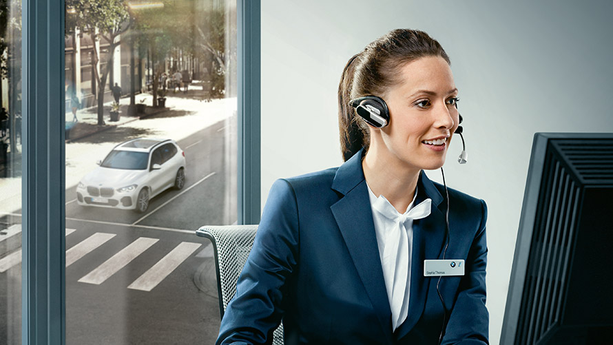 Concierge Services Concierge Services: BMW Mitarbeiterin sitzt mit Headset vor Bildschirm