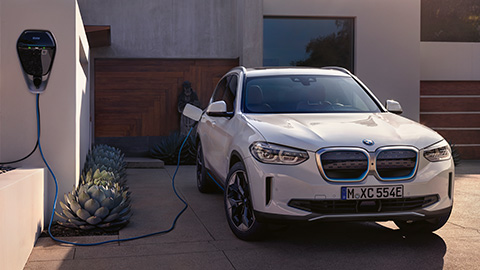 BMW iX3 Dreiviertel-Frontansicht an Ladestation