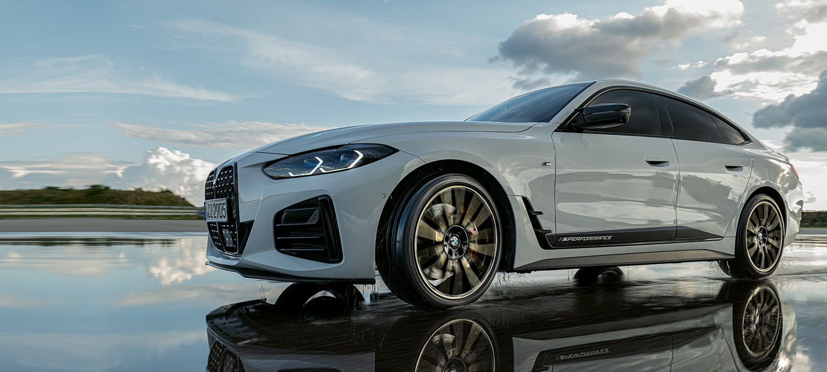 BMW Serie 4 Gran Coupé (G26) con Accessori BMW M Performance Design in movimento su strada bagnata BMW Serie 4 Gran Coupé (G26) con Accessori BMW M Performance Design in movimento su strada bagnata