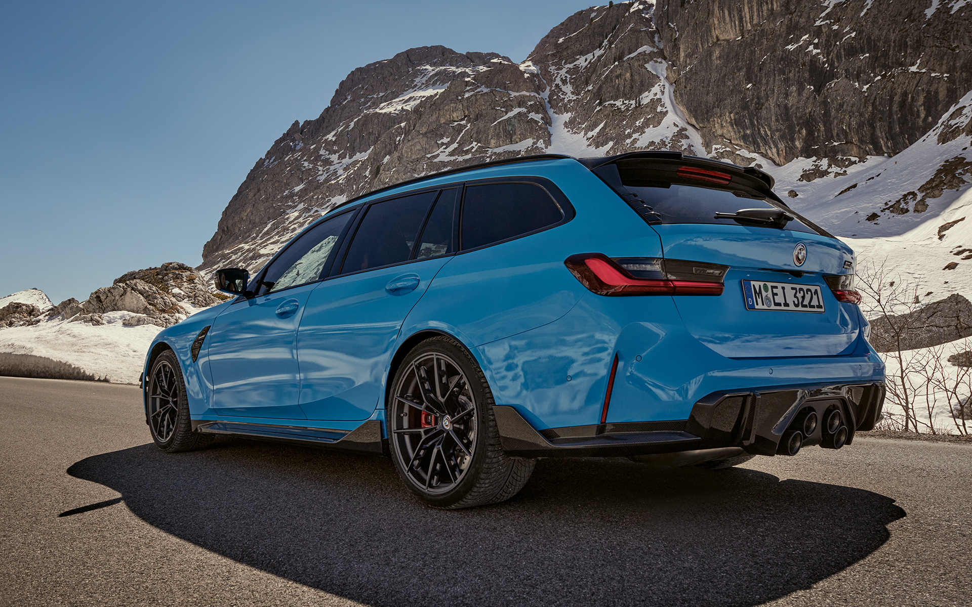 BMW M3 Touring G81 Accessori BMW M Performance Vista laterale a tre quarti in movimento BMW M3 Touring G81 Accessori BMW M Performance Vista laterale a tre quarti in movimento con paesaggio montano sullo sfondo