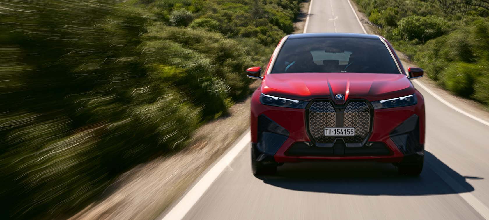 BMW iX xDrive40 BMW iX xDrive40 rosso vista anteriore natura campagna strada