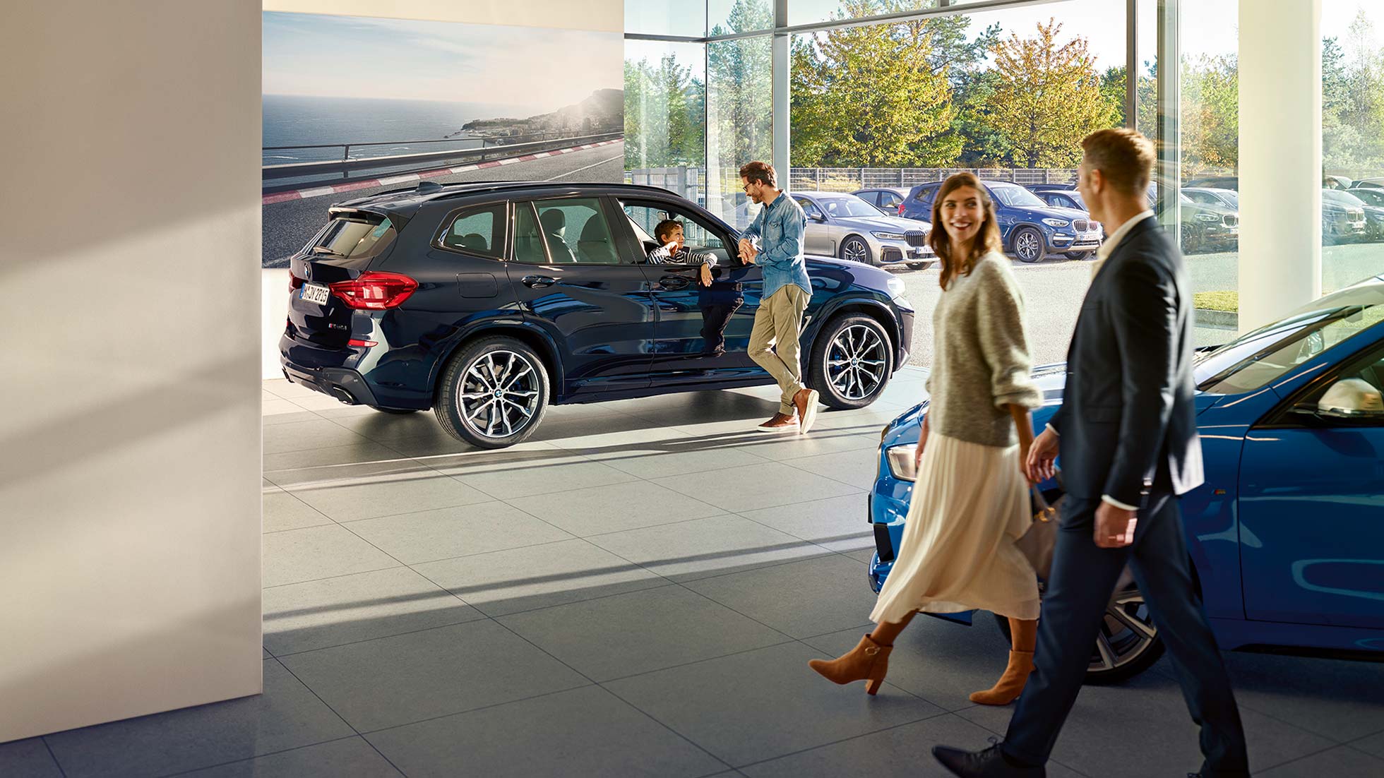 Pacchetto All In BMW, servizi Uomo e donna camminano attraverso lo showroom nel garage BMW.