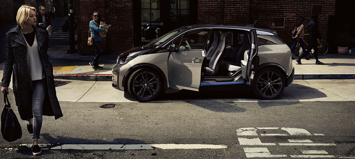 BMW i3 Opendoors BMW i3/grau/schwarz/seitlich/parkiert/offen/Fussgänger/City