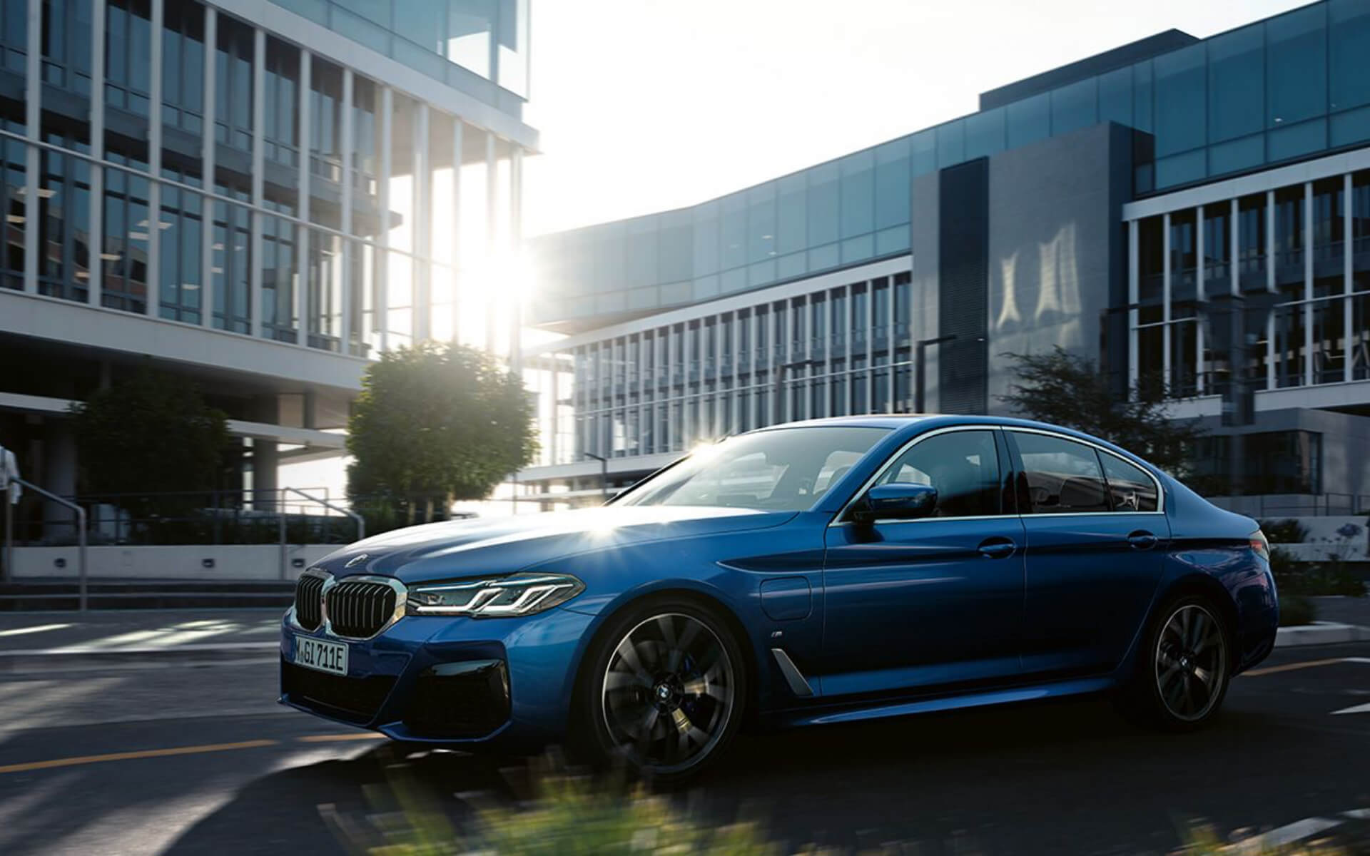 BMW/ 5er Limousine/blau/schräg von der Seite/Bürogebäude/Stadt