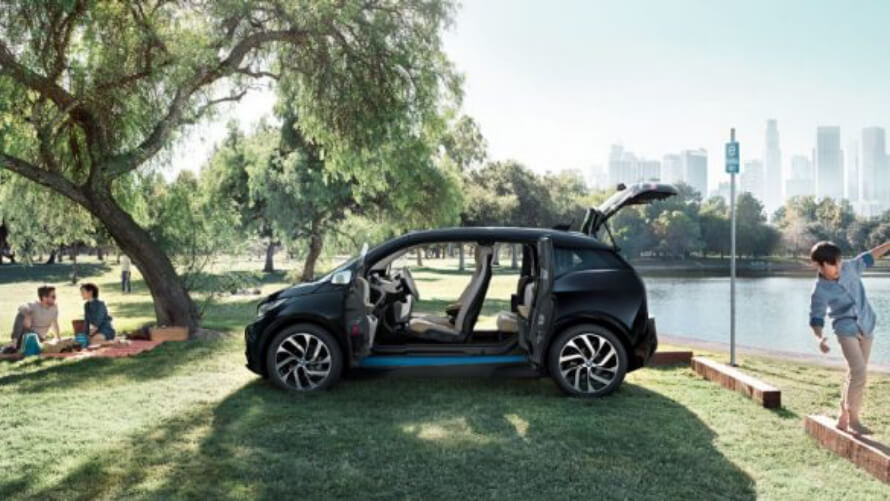 Porte e porta del bagagliaio aperte BMW i3 Porte e porta del bagagliaio aperte/BMW/i3/nera/prospettiva/famiglia a un picnic/parco