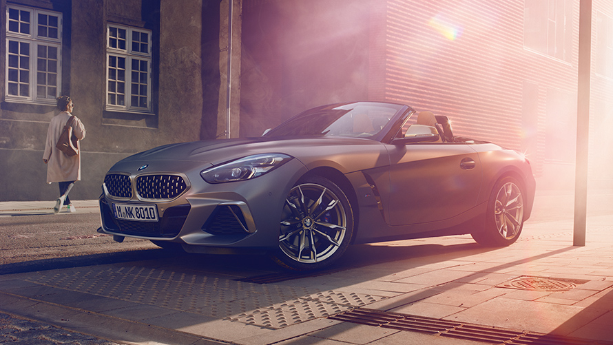 Frau BMW Z4 Roadster Frau BMW Z4 Roadster anthrazit seitlich von vorne Seitenstrasse Stadt