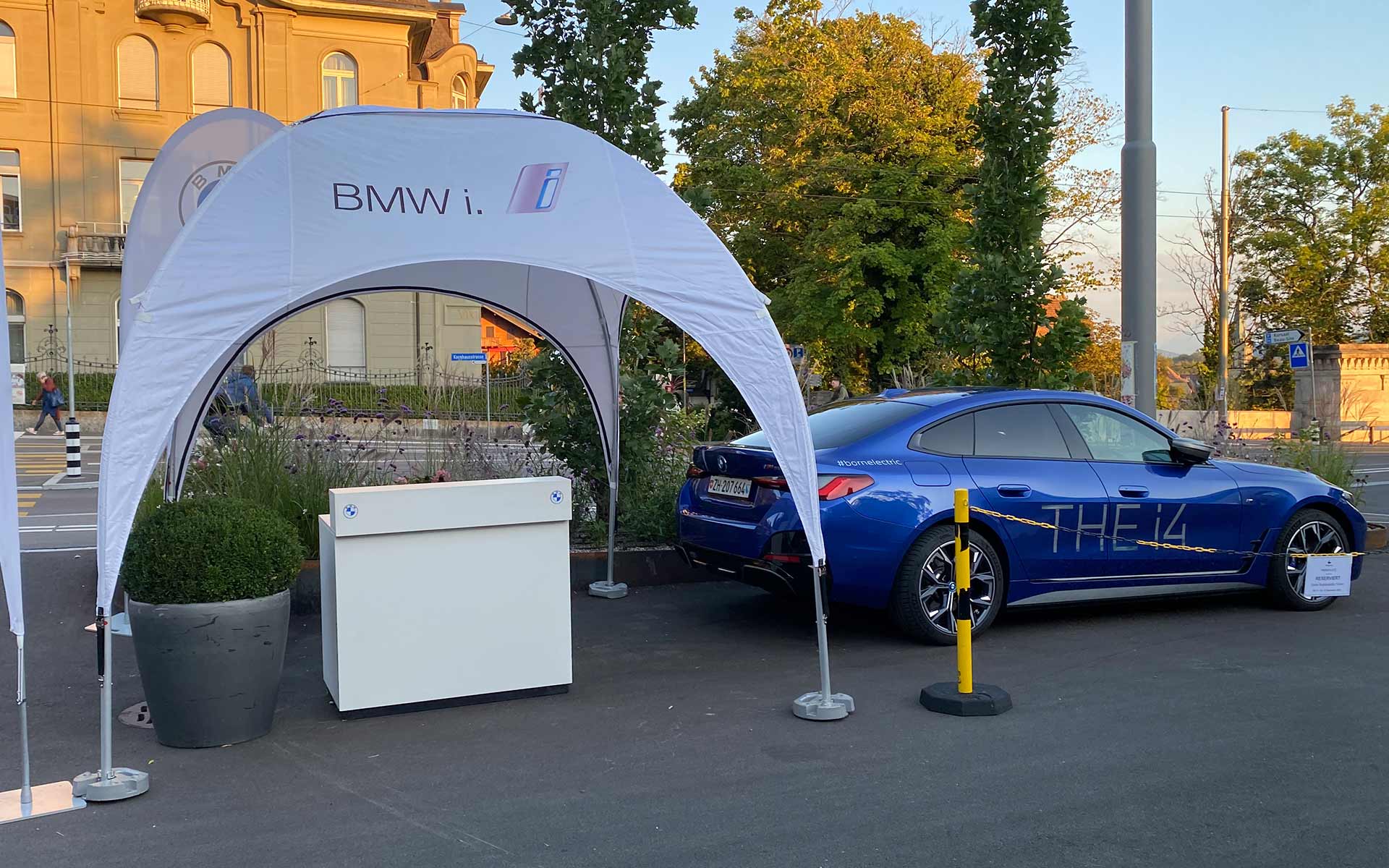 BMW i4 en vue de trois quarts-quarts latérale à droite de la tente de l’événement