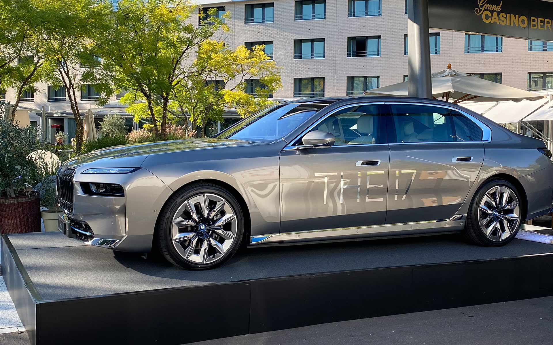 BMW i7 en vue latérale sur la scène de présentation devant le bâtiment