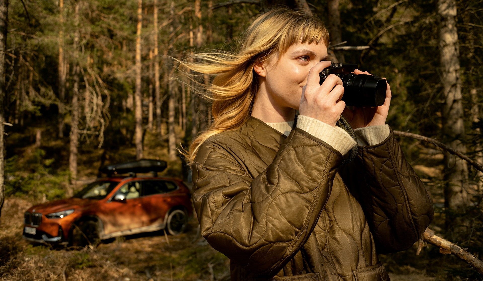 Frau mit Kamera vor BMW im Herbst BMW Feriencheck Frau mit Kamera vor BMW im Herbst